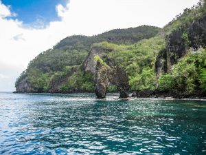 Rock formations on the coast with jungle and mountains in St Vincent, The Caribbean