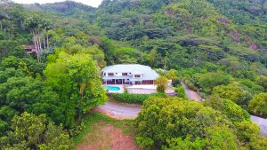 Drone view of large hourse amongst rainforest in Mahe island, Seychelles