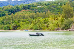 Boat by beach and forest on Mahe island, Seychelles