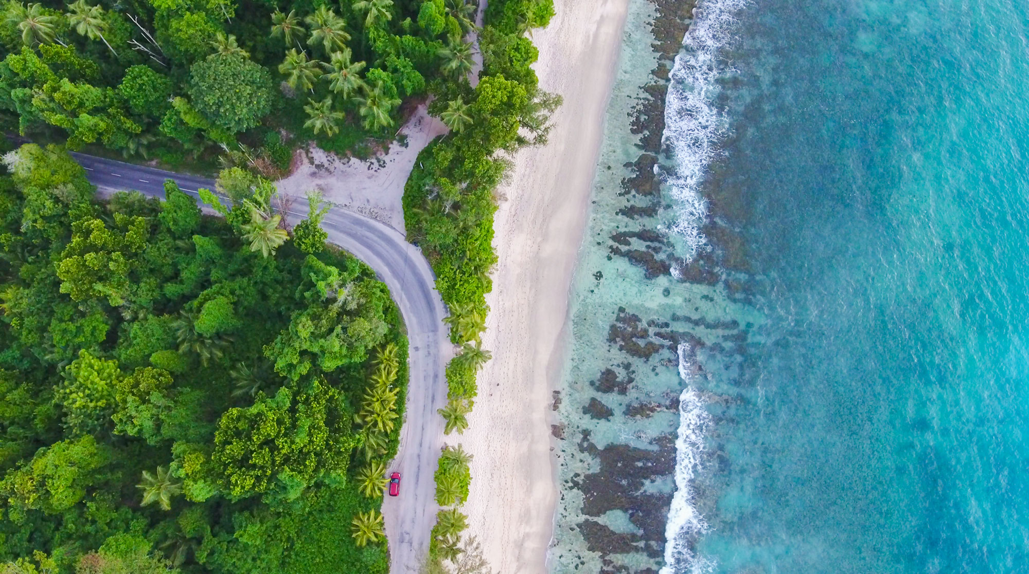 Drone view of Takamaka beach, jungle and ocean on Mahe island, Seychelles