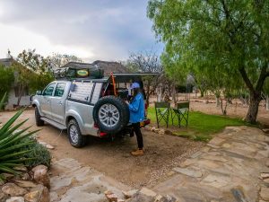 Ella with Toyota Hilux 4x4 with roof-top tent on campsite near Windhoek in Namibia