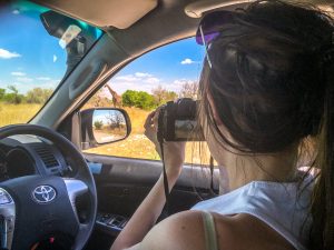 Ella photographing a giraffe on safari in Etosha National Park, Namibia, Africa