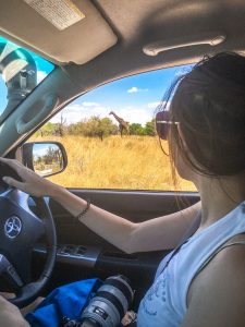 Ella photographing a giraffe on safari in Etosha National Park, Namibia, Africa