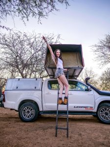 Ella with Toyota Hilux 4x4 with roof-top tent in Onguma Reserve near Etosha National Park in Namibia, Africa