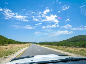 Empty road and savannah - driving from Etosha National Park to Damaraland in Namibia, Africa
