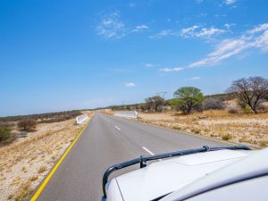 Empty road and savannah - driving from Etosha National Park to Damaraland in Namibia, Africa