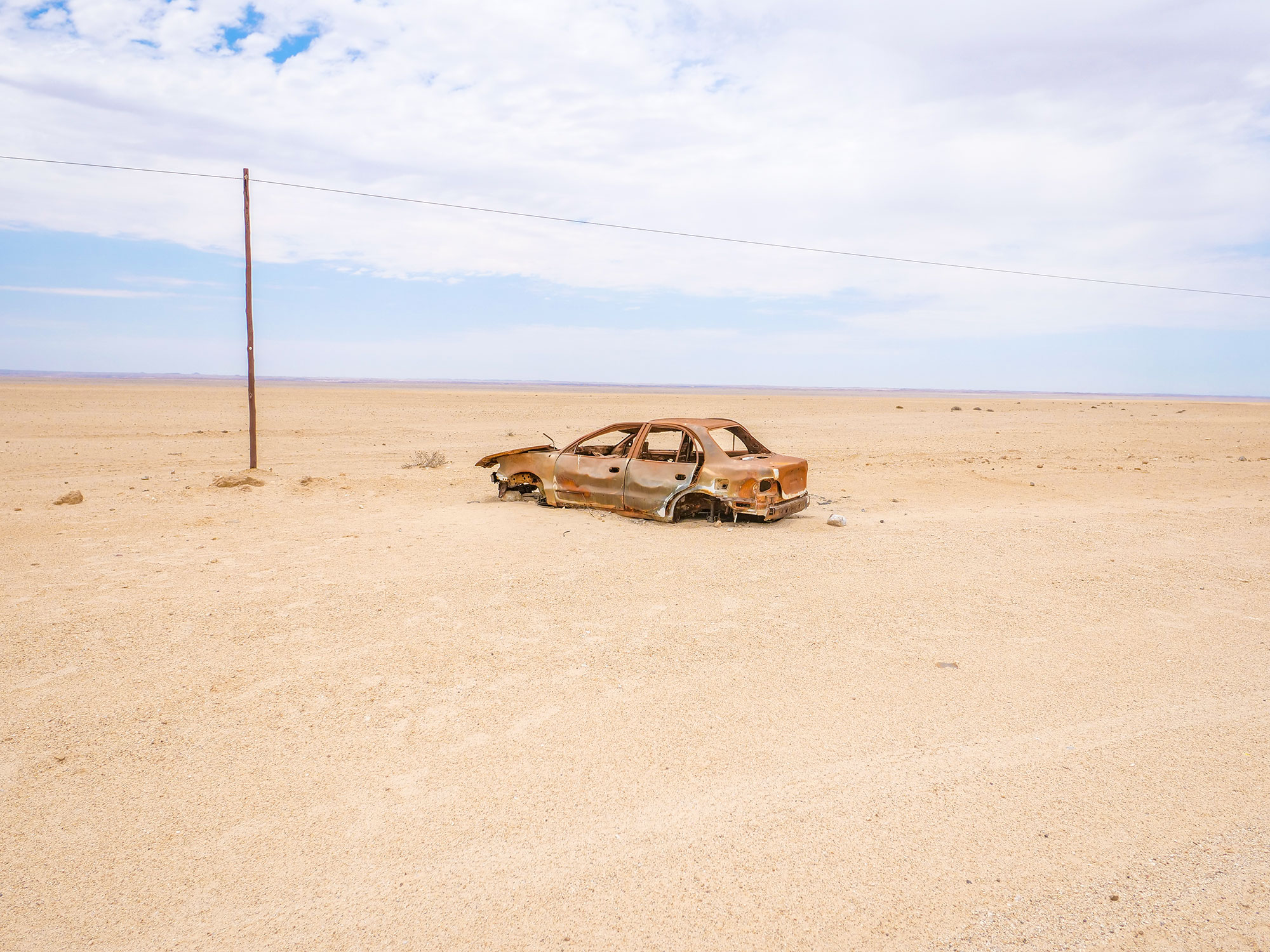 Rusted car wreck on self-drive through the desert in the Skeleton Coast, Namibia, Africa