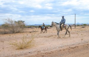 Namibians on horeback in the desert in Damaraland, Namibia, Africa