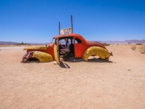 Ella in rusty car at Solitaire in Namib Desert, Namibia, Africa