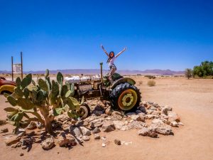 Ella on rusty tractor at Solitaire in Namib Desert, Namibia, Africa