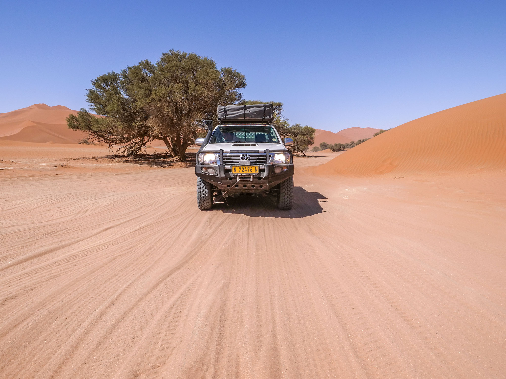 Toyota Hilux self-drive 4x4 in Sossusvlei with sand dunes, Namib Desert in Namibia, Africa