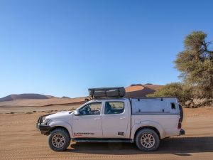 Toyota Hilux self-drive 4x4 in Sossusvlei with sand dunes, Namib Desert in Namibia, Africa