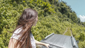 Ella McKendrick riding on a 4x4 truck in the rainforest in Dominica
