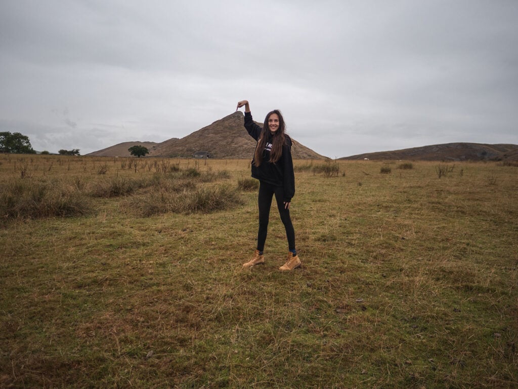 Ella McKendrick pointing to the summit of Thorpe Cloud, Peak District