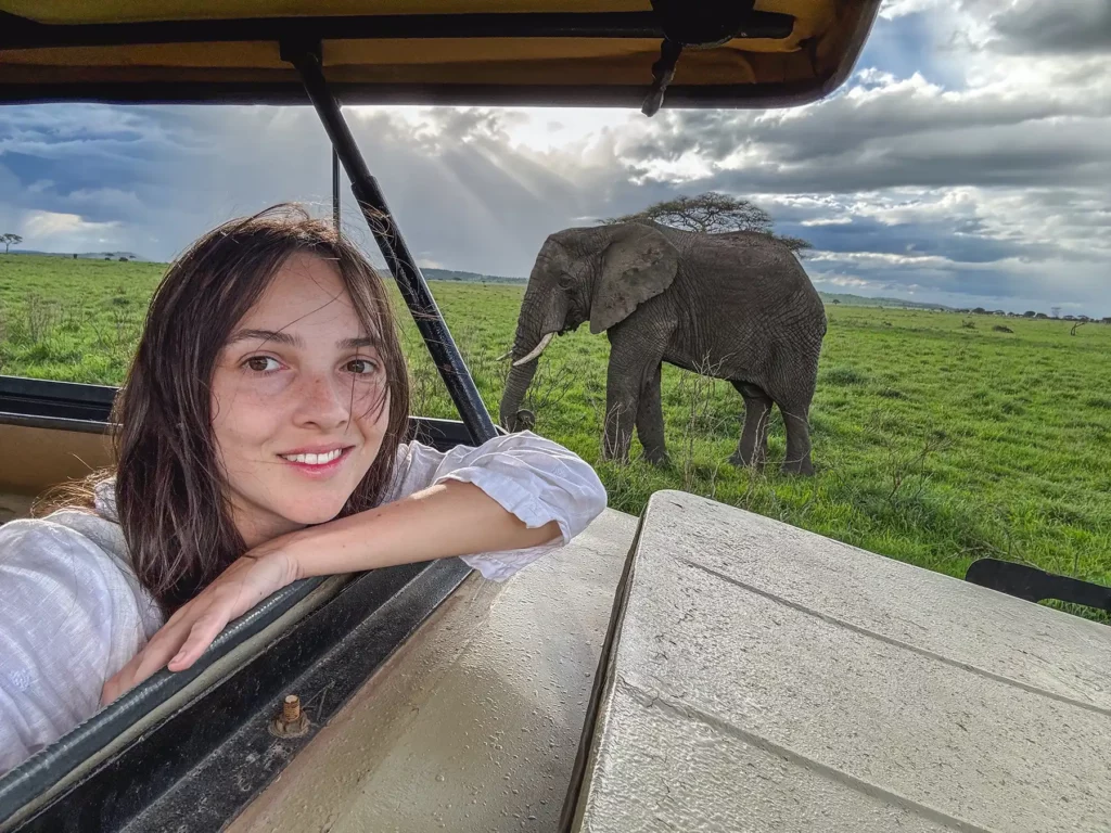 Ella McKendrick on safari with an Elephant in the background in Serengeti, Tanzania