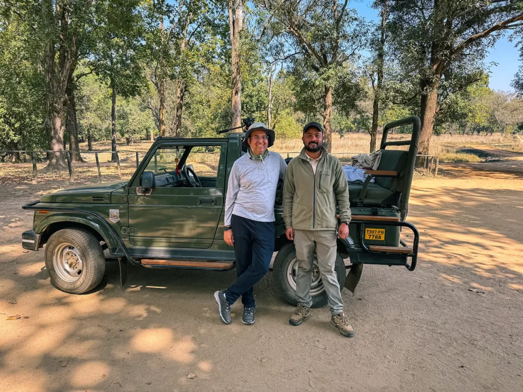 Tiger safari guide and driver stood in front of safari truck