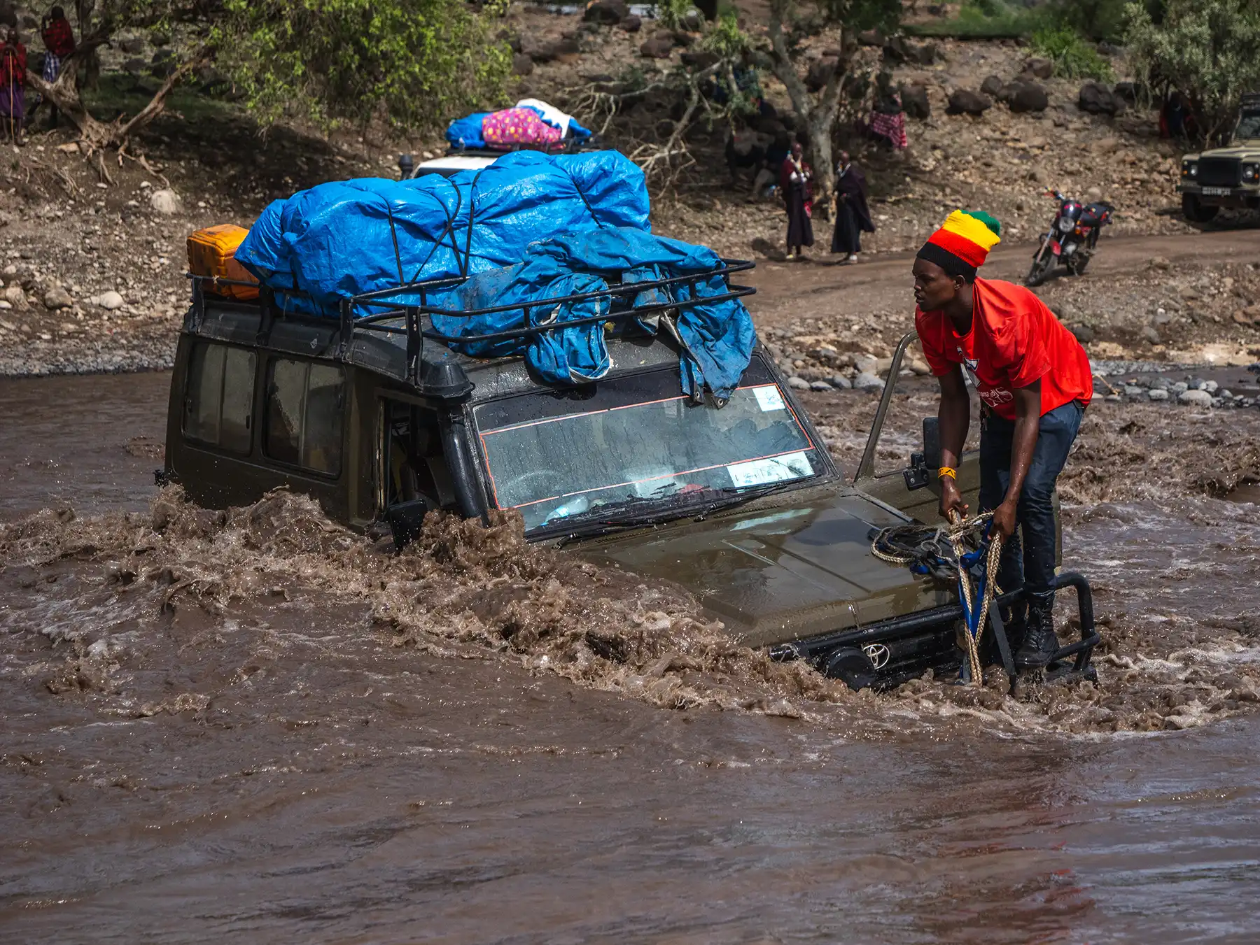 Self-driving can quickly become hazardous due to deep hidden potholes. This was actually a normal road which quickly flooded after heavy rain and trapped inexperienced drivers. Luckily my experienced driver guide knew not to attempt a crossing. This driver was lucky as we were able to rescue him but the car was ruined with water damage.