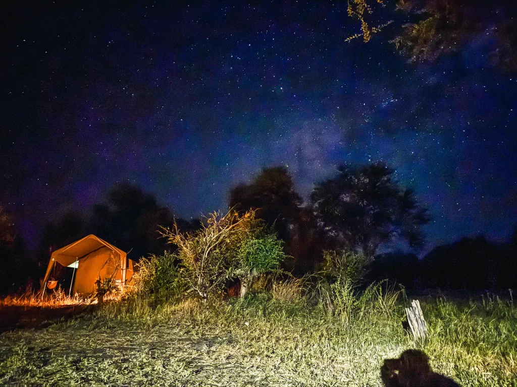 Botswana mid-range safari in luxury mobile tented camp. Picture showing starts over tent accommodation at night.