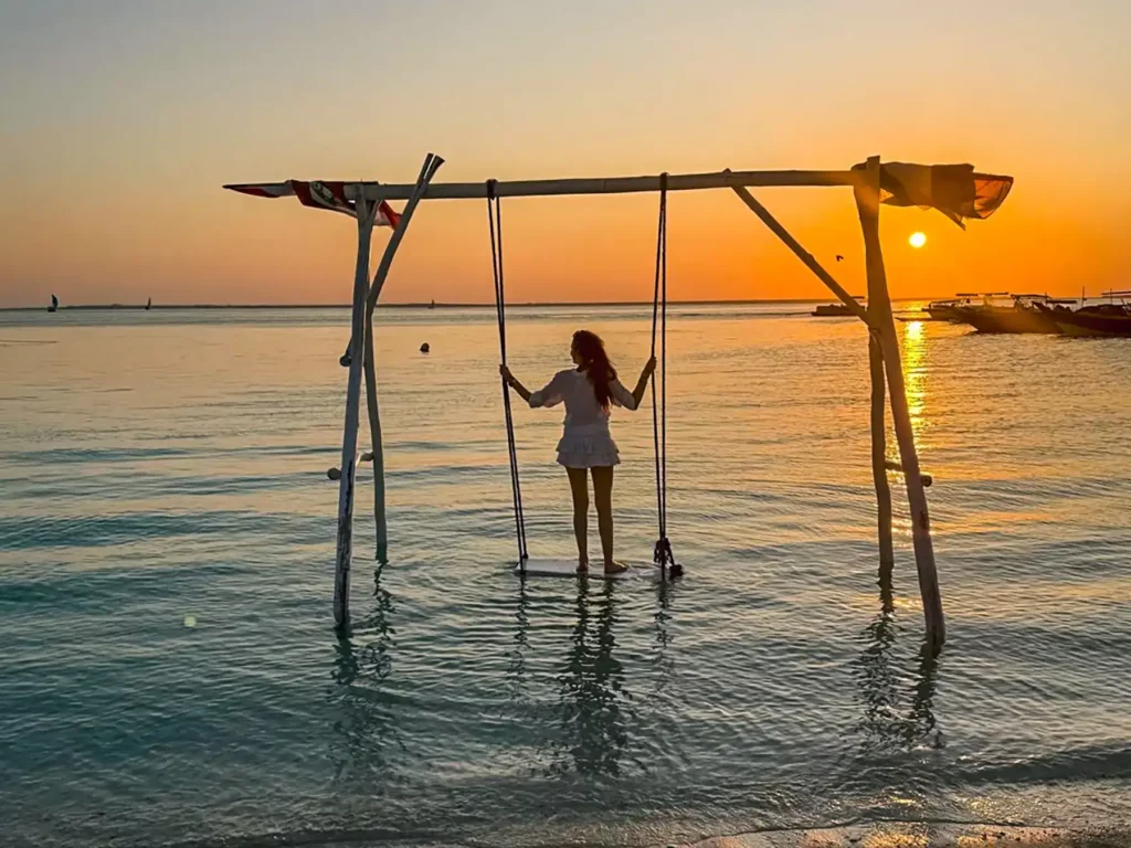 Ella McKendrick watching the sun set on a swing in Nugwi beach in Northern Zanzibar