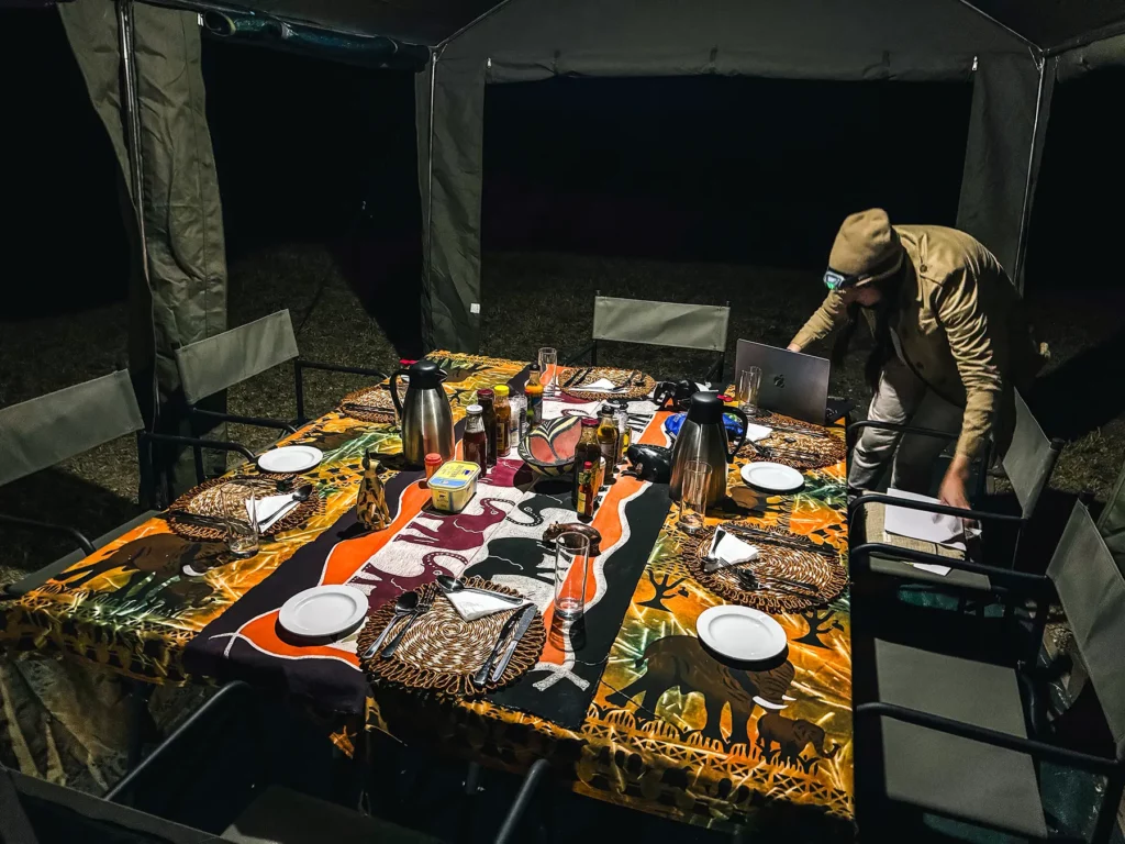 Ella McKendrick checking the days photos after dinner at a mobile tented camp in Khwai Community Area, Botswana