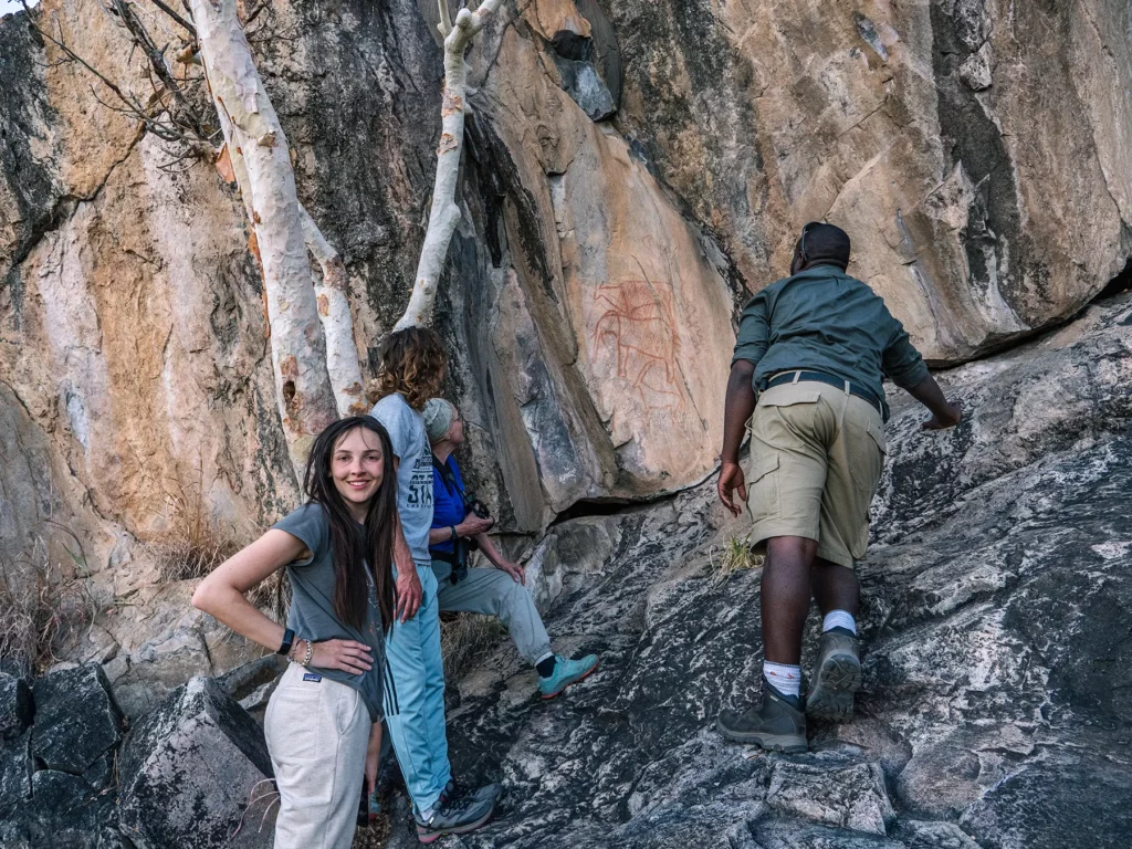 Ella Mckendrick looking at ancient paintings in Savuti, Chobe National Park, Botswana