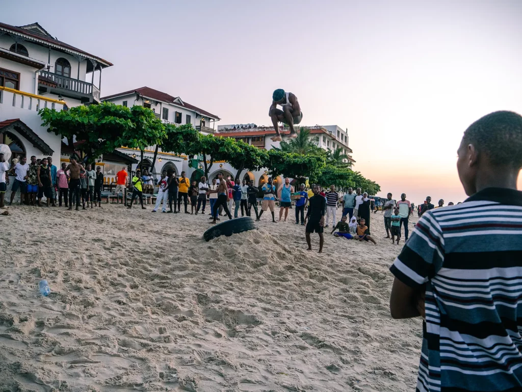 Locals doing jumping acrobatics on the beach in Stone Town, Zanzibar