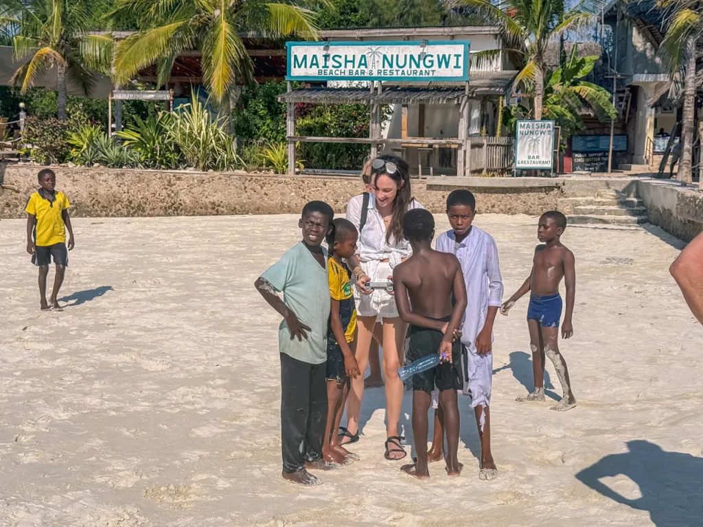 Ella McKendrick with local children on Nungwi Beach, Zanzibar