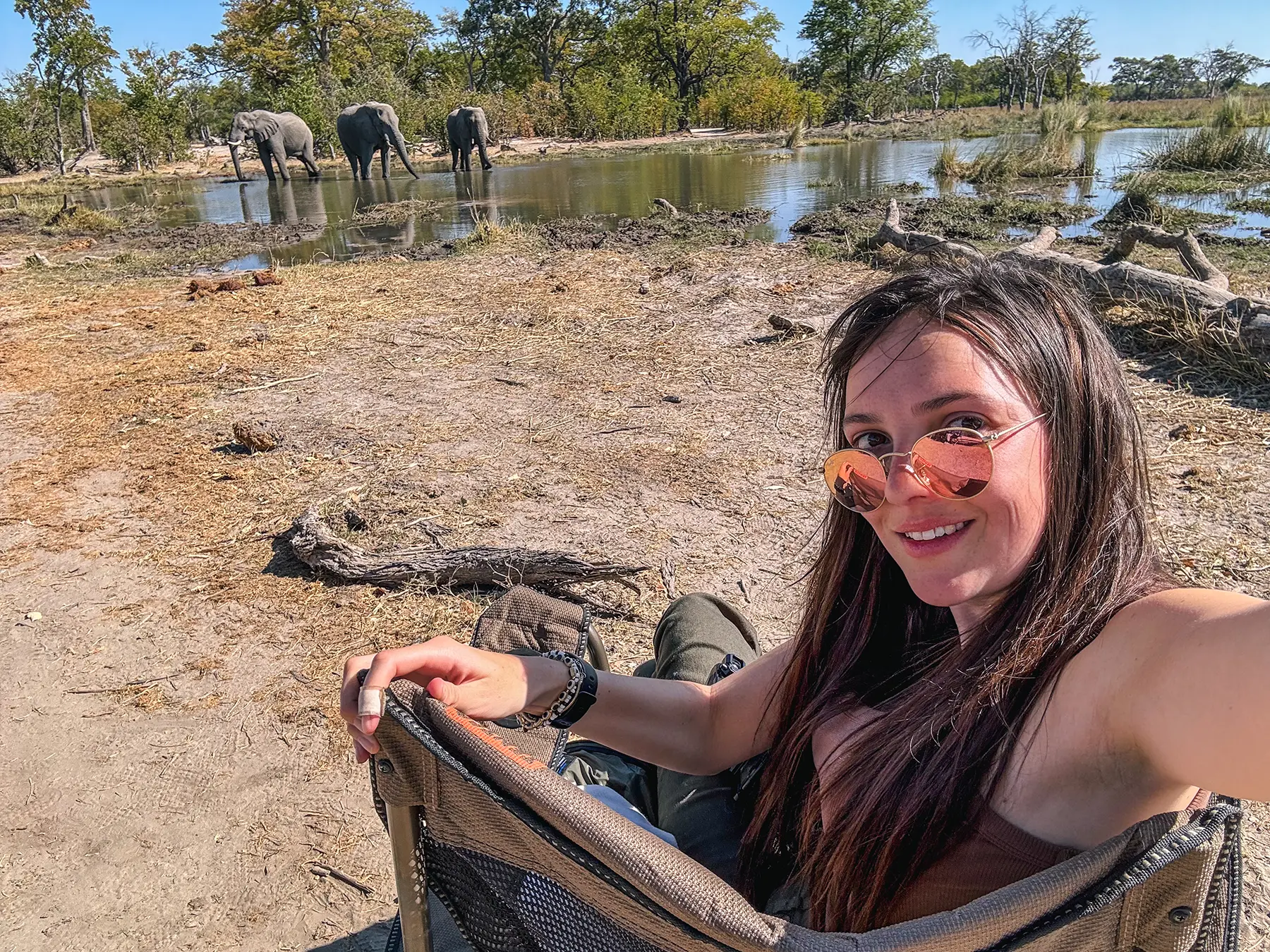 Ella McKendrick having lunch whilst watching elephants in Moremi Game Reserve, Okavango Delta, Botswana