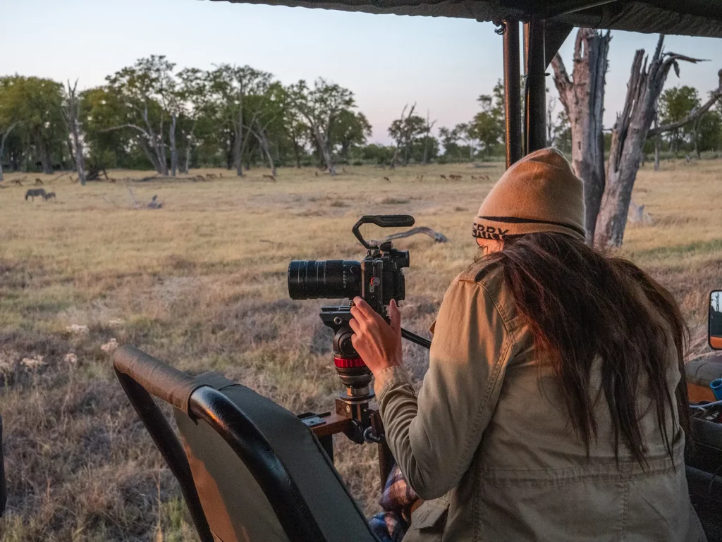 Ella McKendrick photographing from safari truck in Moremi Game Reserve, Okavango Delta, Botswana