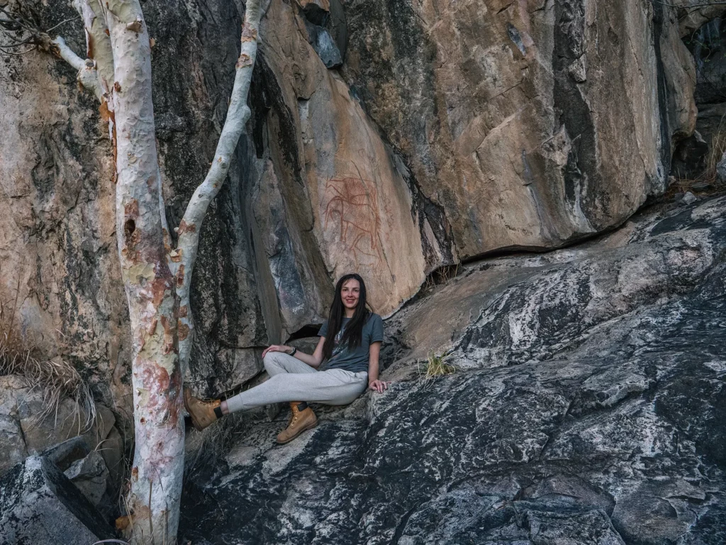 Ella Mckendrick looking at ancient paintings in Savuti, Chobe National Park, Botswana