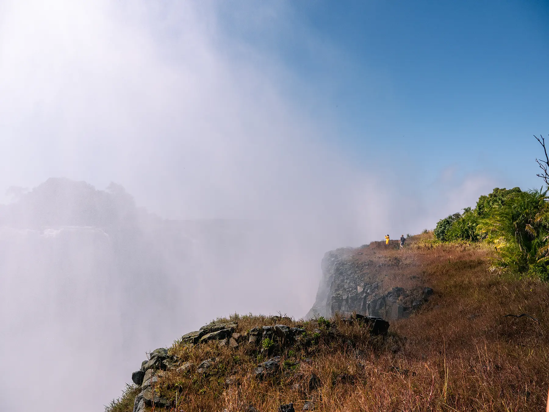 Dramatic view of Victoria Falls from the Zimbabwean side. A powerful plume of mist rising from the gorge, created by the force of the water plunging over the edge.