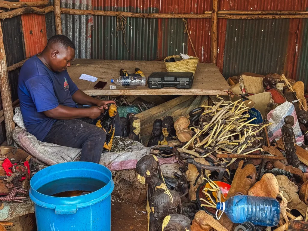 Craftsman carving some wooden animal souvenirs in Kenya