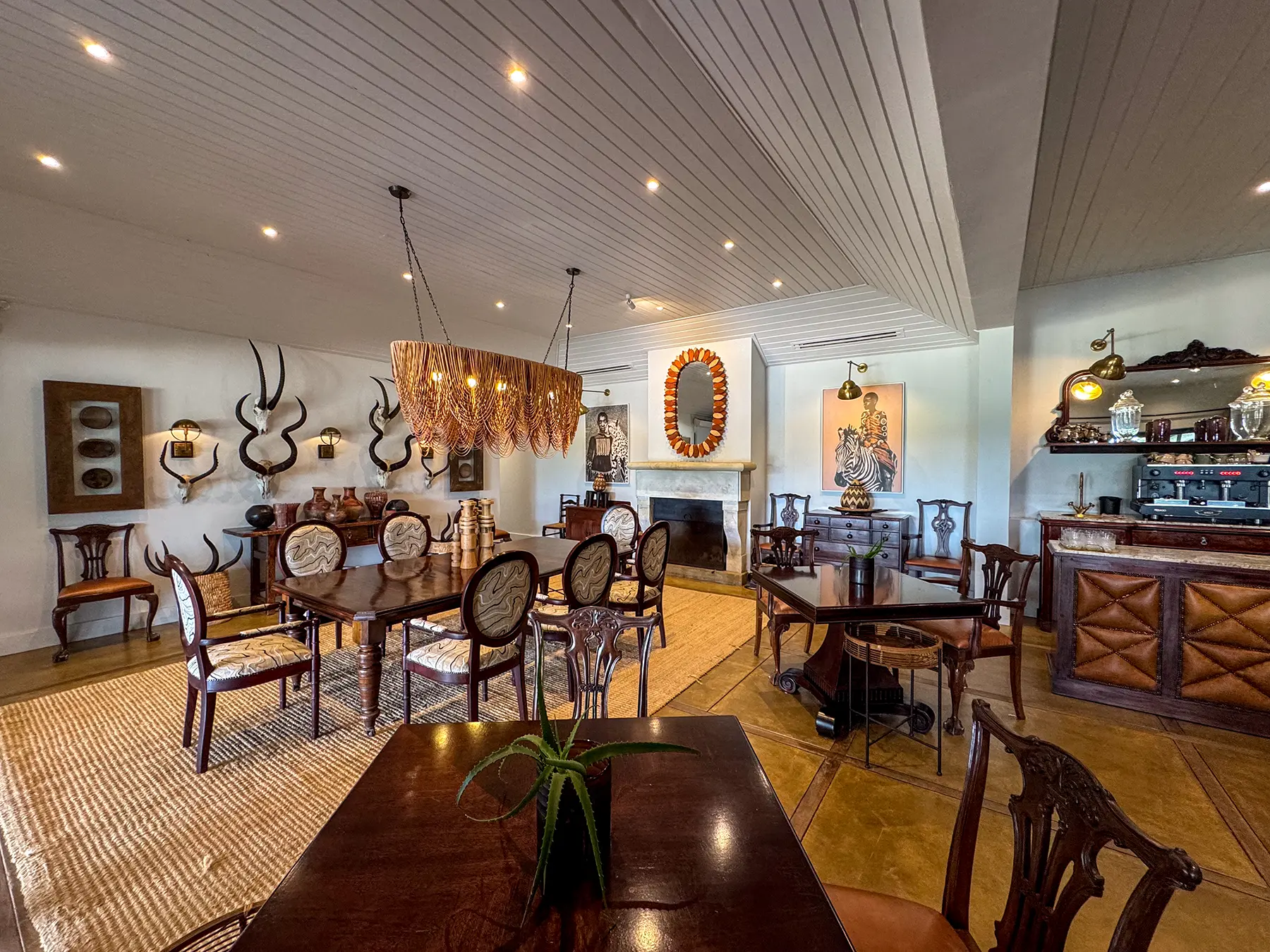 A dining room with antique wooden furniture, mounted antelope horns and an ornate bar area at a safari lodge on safari in the Sabi Sand Game Reserve, South Africa