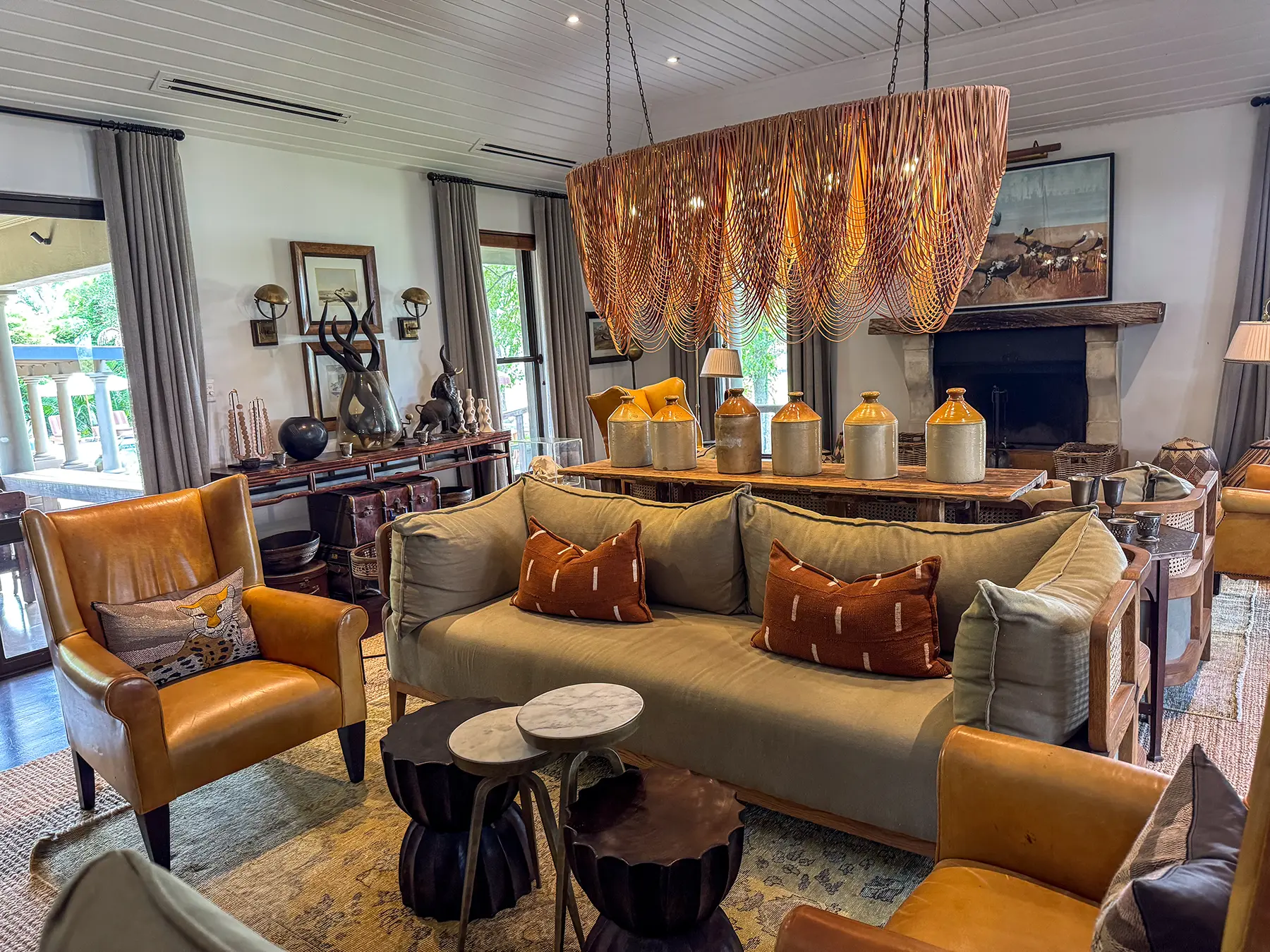 The main lounge with a large leaf-shaped chandelier, leather armchairs and olive-green sofas at a safari lodge on safari in the Sabi Sand Game Reserve, South Africa