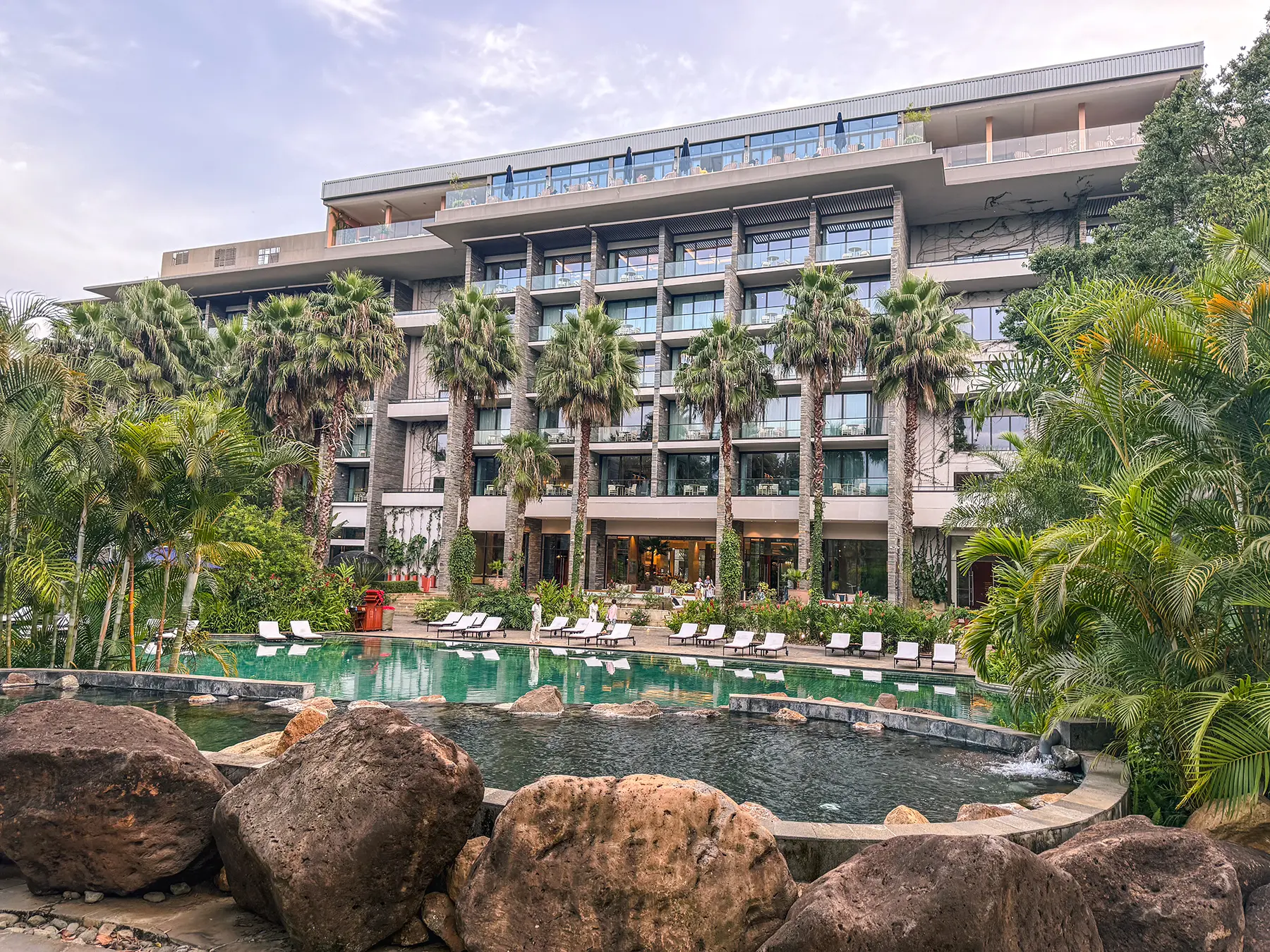 Large hotel building with a pool and palm trees in Arusha, Tanzania