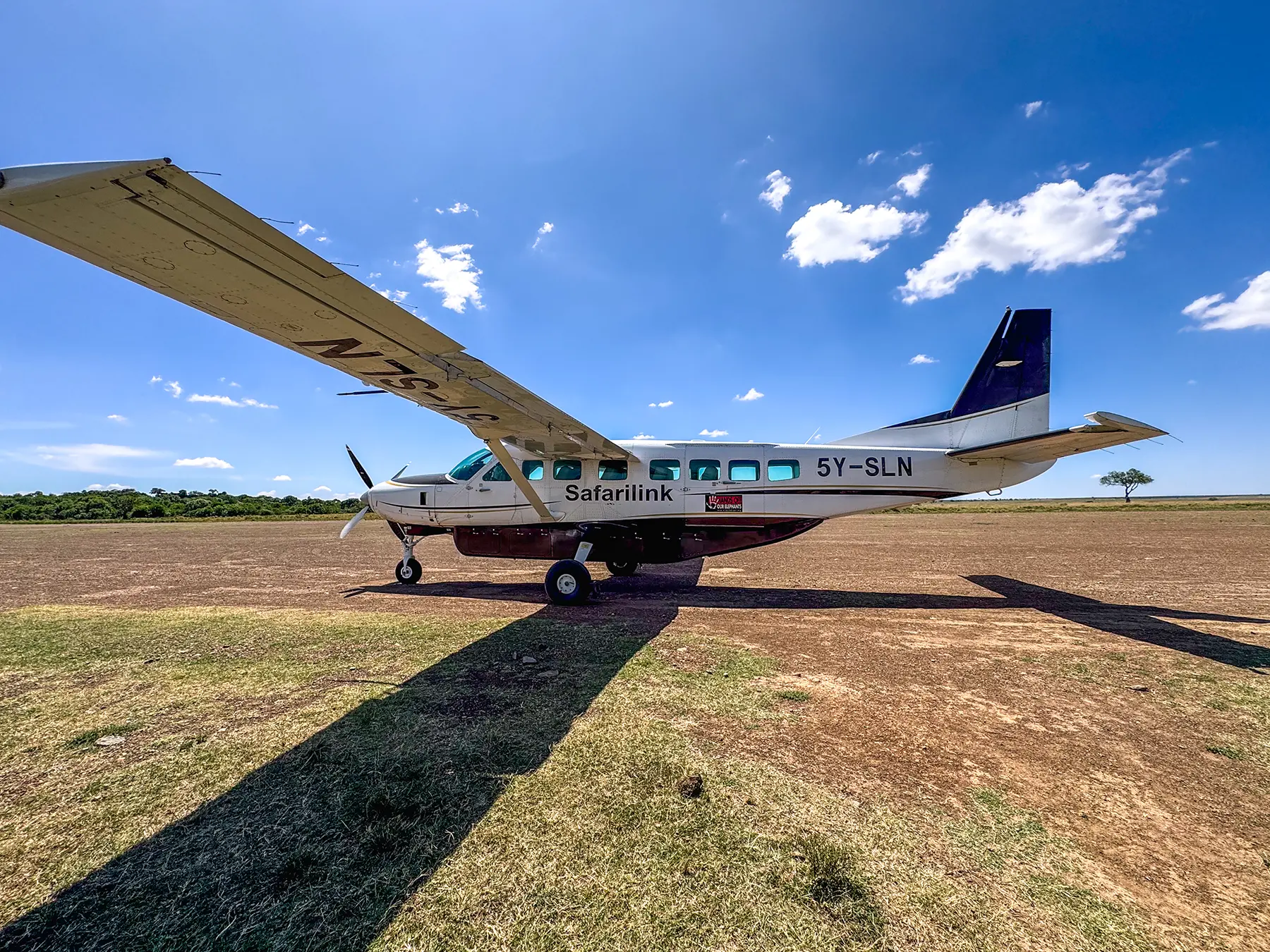 Safarilink Cessna Caravan aircraft parked on a bush airstrip in Maasai Mara National Reserve, Kenya