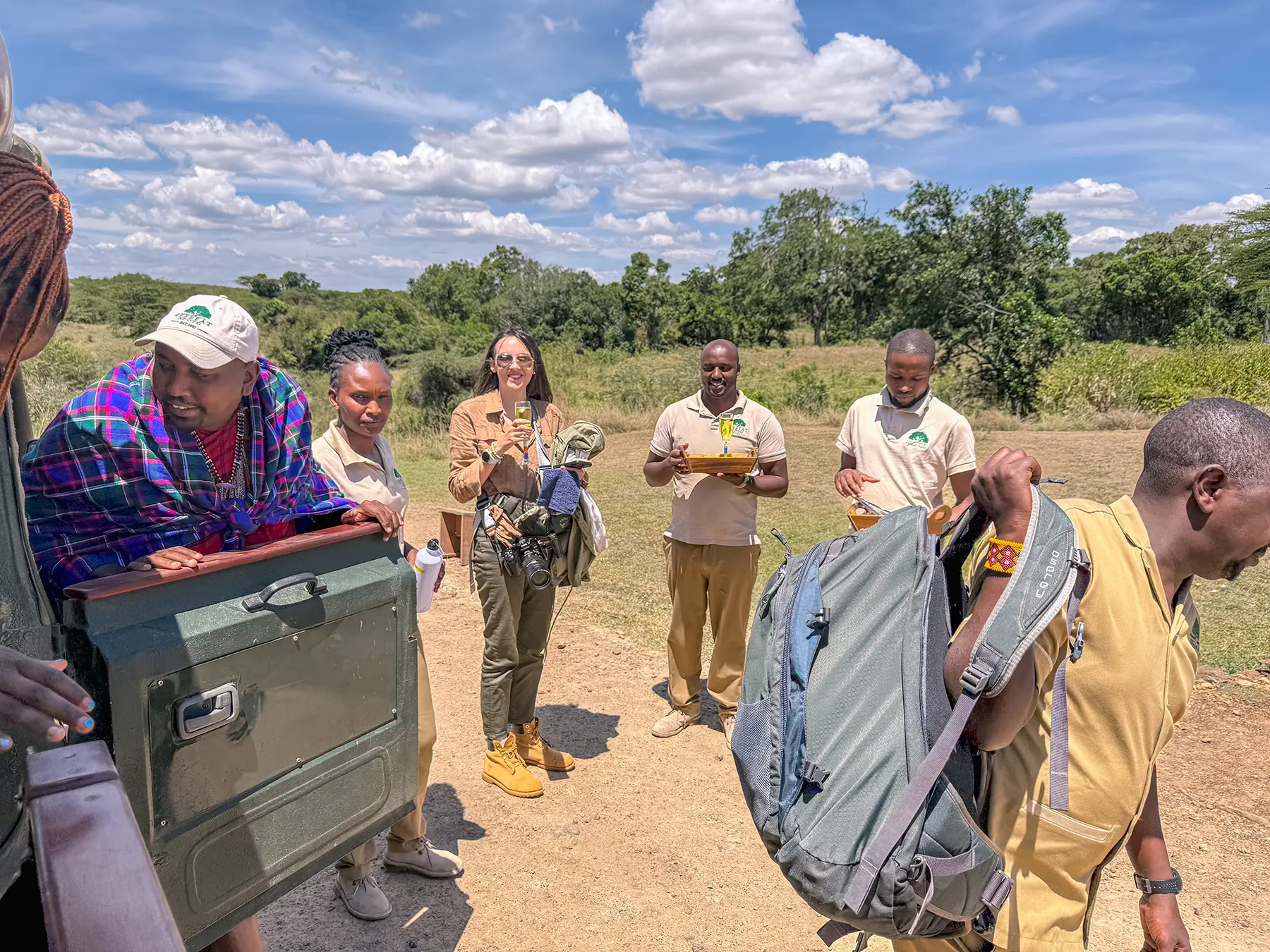 Ella McKendrick arriving at a bush airstrip with guides and camp staff in Maasai Mara National Reserve, Kenya