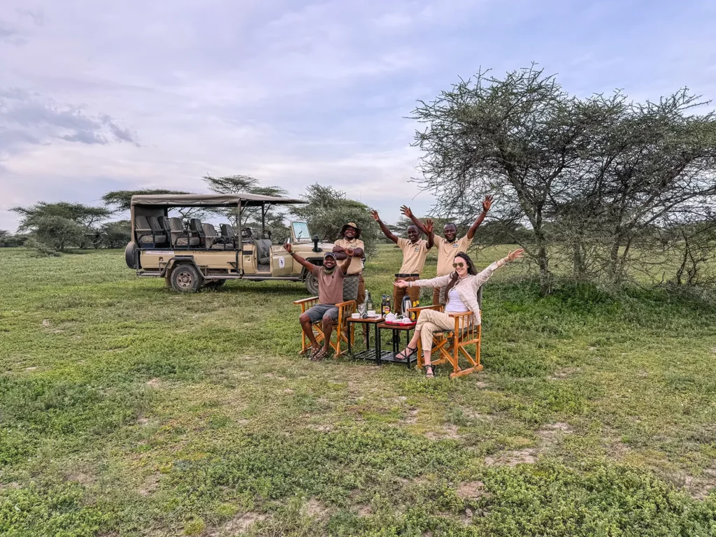 Ella McKendrick and safari guides celebrating at a sundowner stop in Ndutu, Southern Serengeti, Tanzania