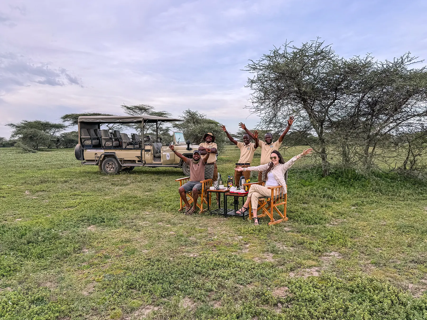Ella McKendrick and safari guides celebrating at a sundowner stop in Ndutu, Southern Serengeti, Tanzania