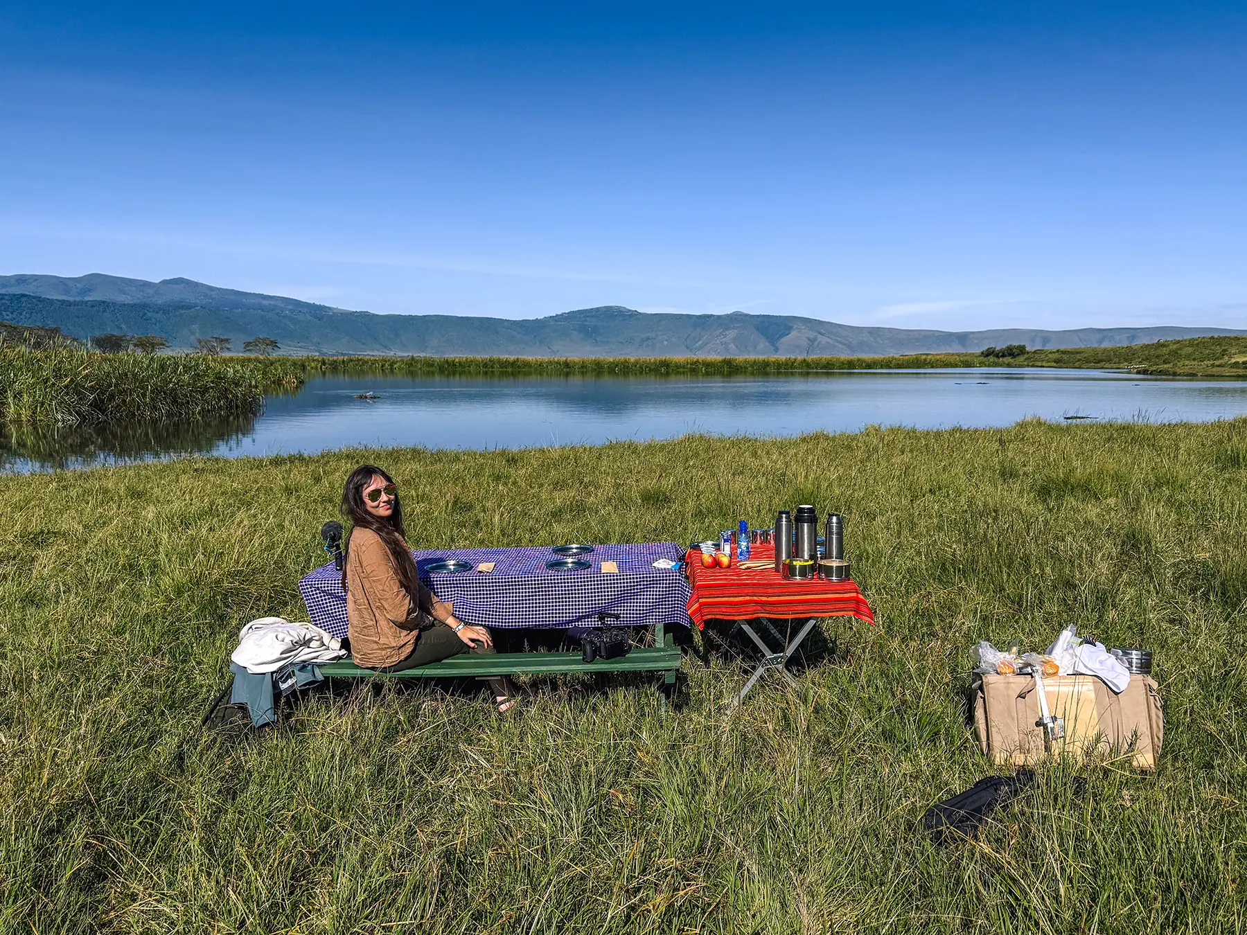 Ella McKendrick seated at a breakfast table beside a lake on the Ngorongoro Crater floor, Tanzania