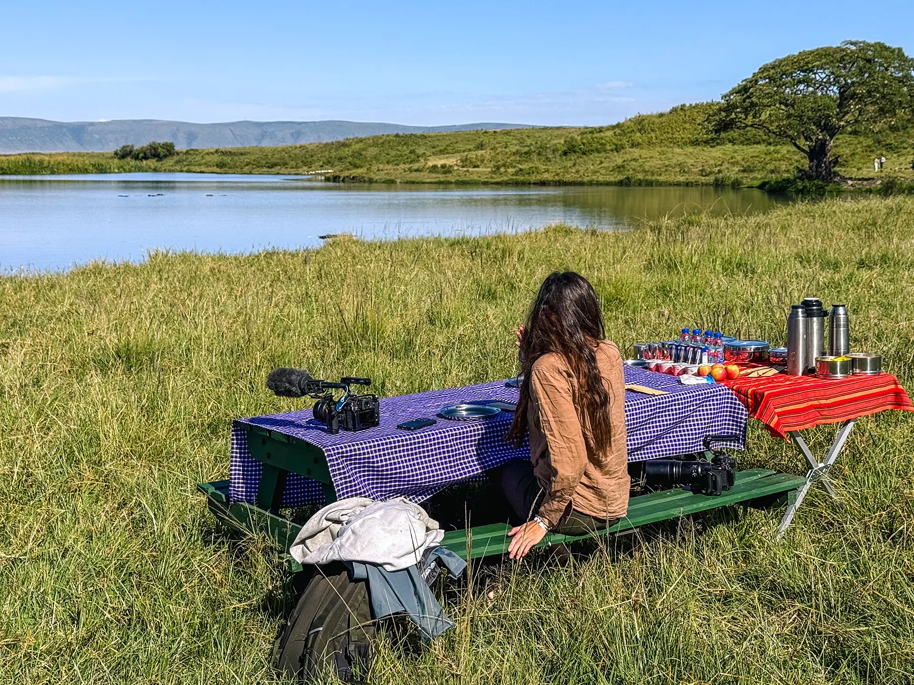 Ella McKendrick seated at a picnic table overlooking a lake on the Ngorongoro Crater floor in Tanzania