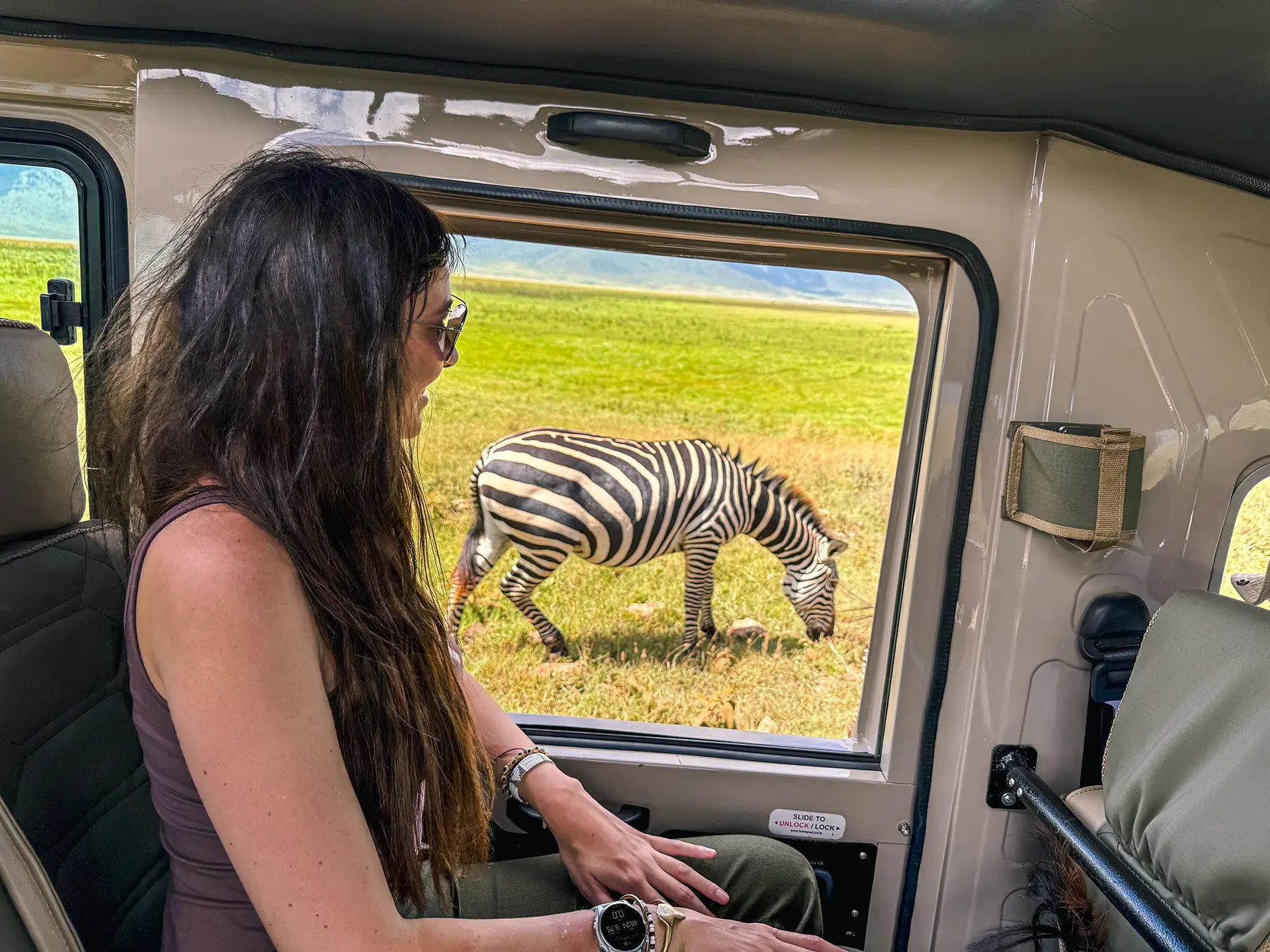 Ella McKendrick watching a zebra grazing from inside a safari vehicle in Ngorongoro Crater, Tanzania