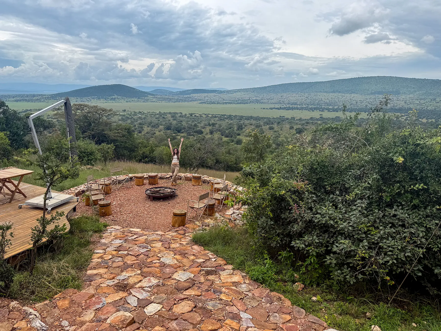 Ella McKendrick at the stone firepit boma with sweeping savanna view at Karenge Bush Camp in Akagera National Park, Rwanda
