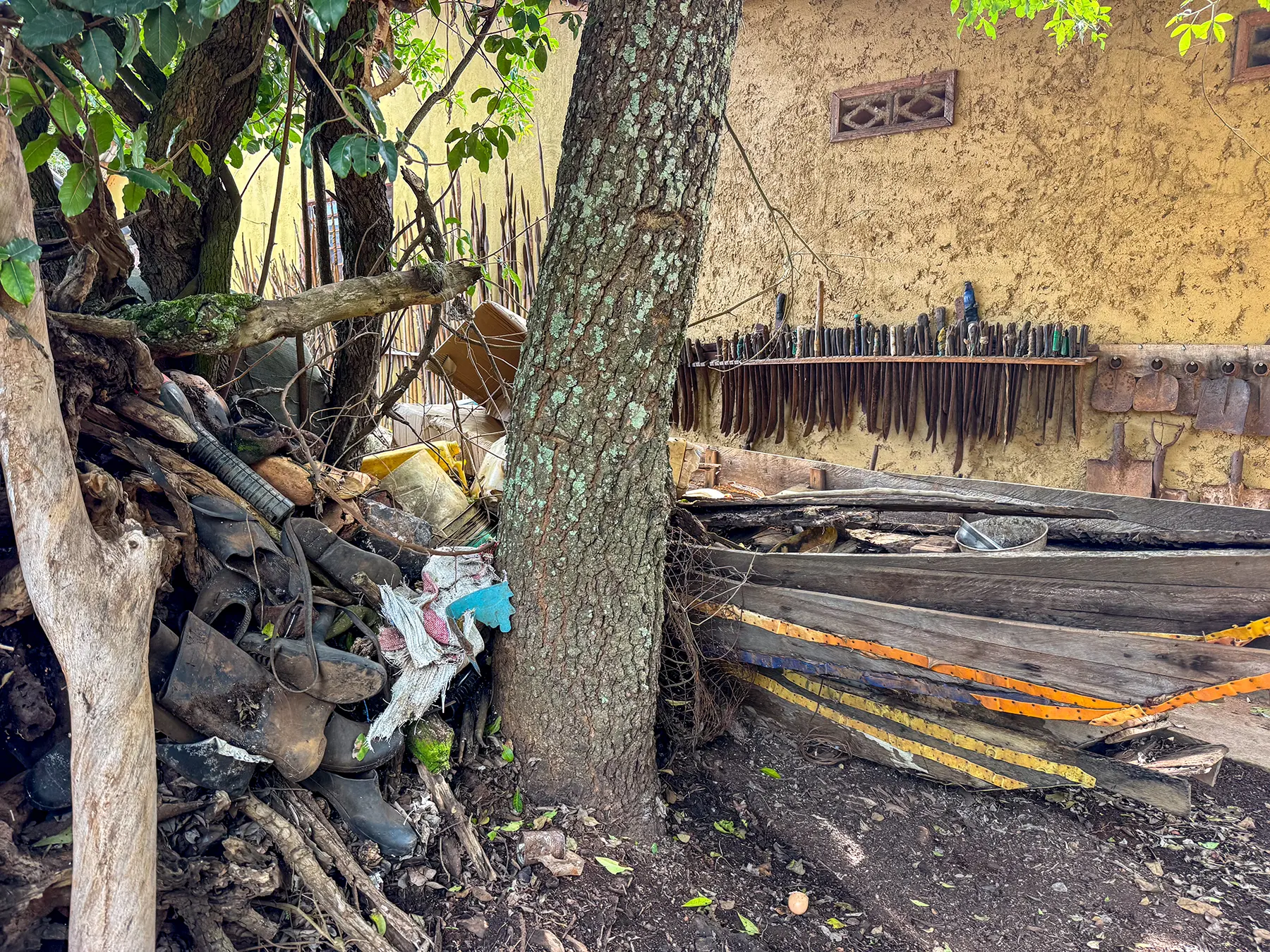 Confiscated poacher boats, knives and equipment displayed beside a mud wall at Akagera National Park headquarters, Rwanda