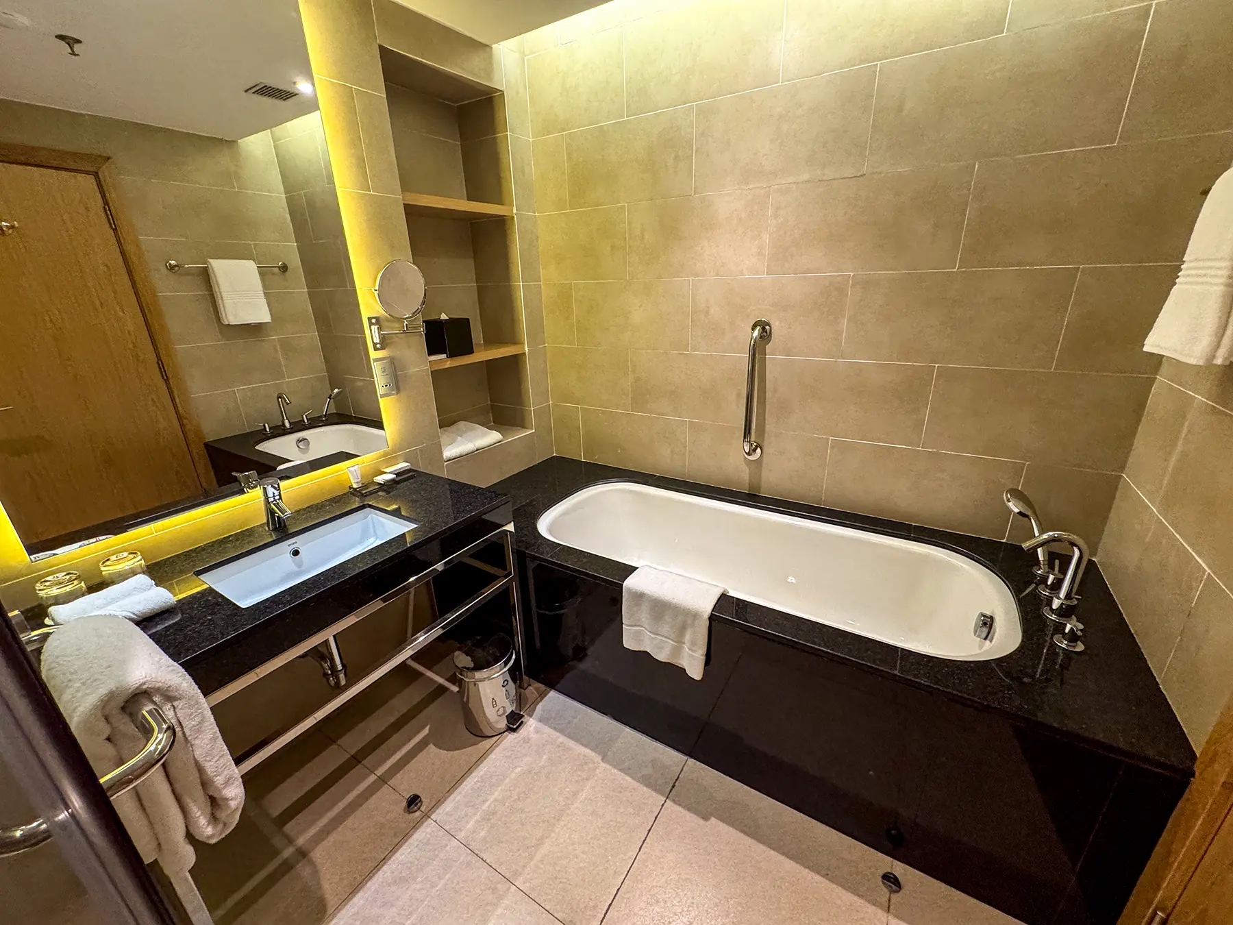 Hotel bathroom with stone tiled bathtub vanity and folded towels at Kigali Marriott in Kigali, Rwanda
