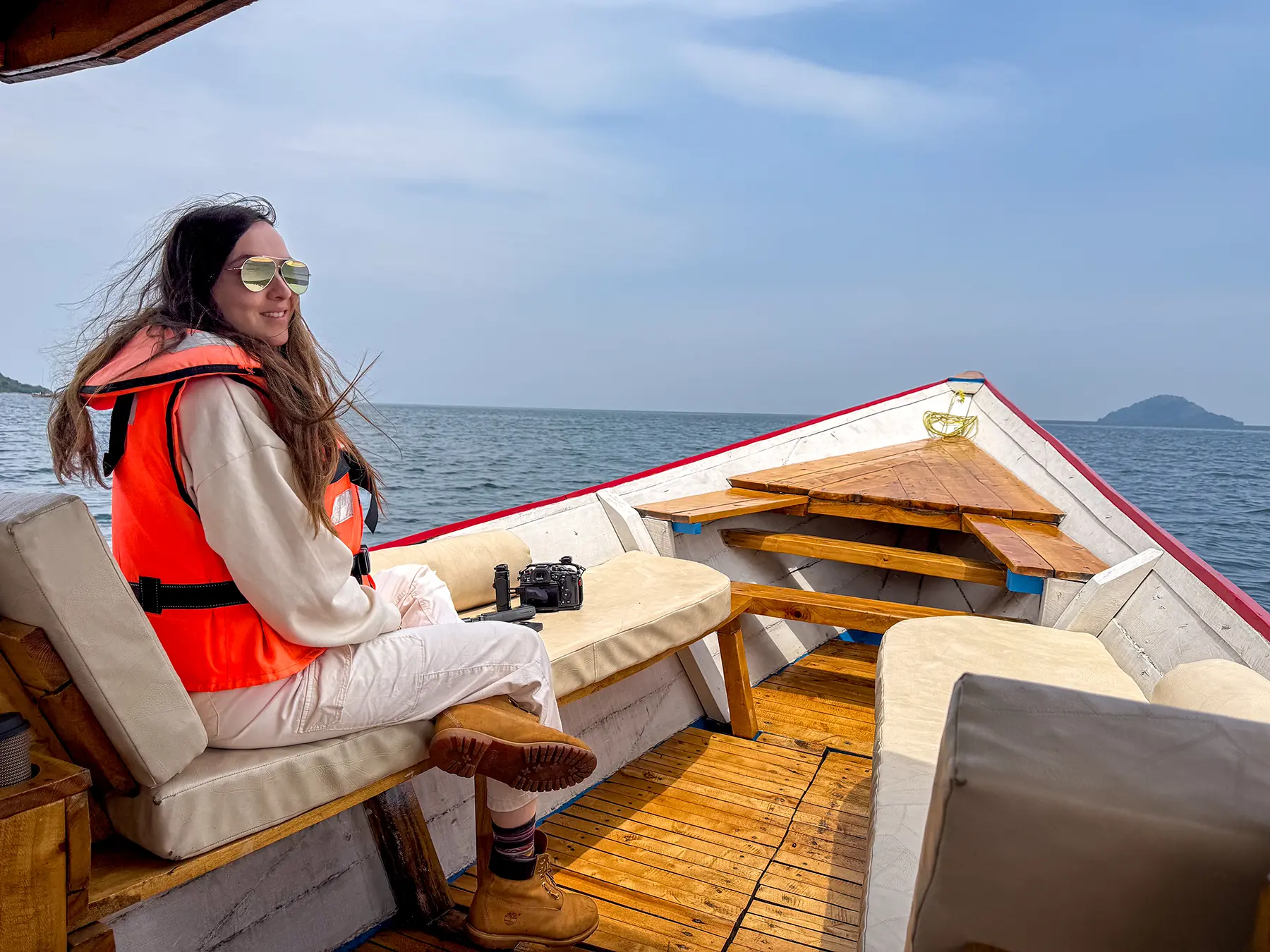 Ella McKendrick in a lifejacket and sunglasses on a wooden cruise boat at Lake Kivu, Rwanda