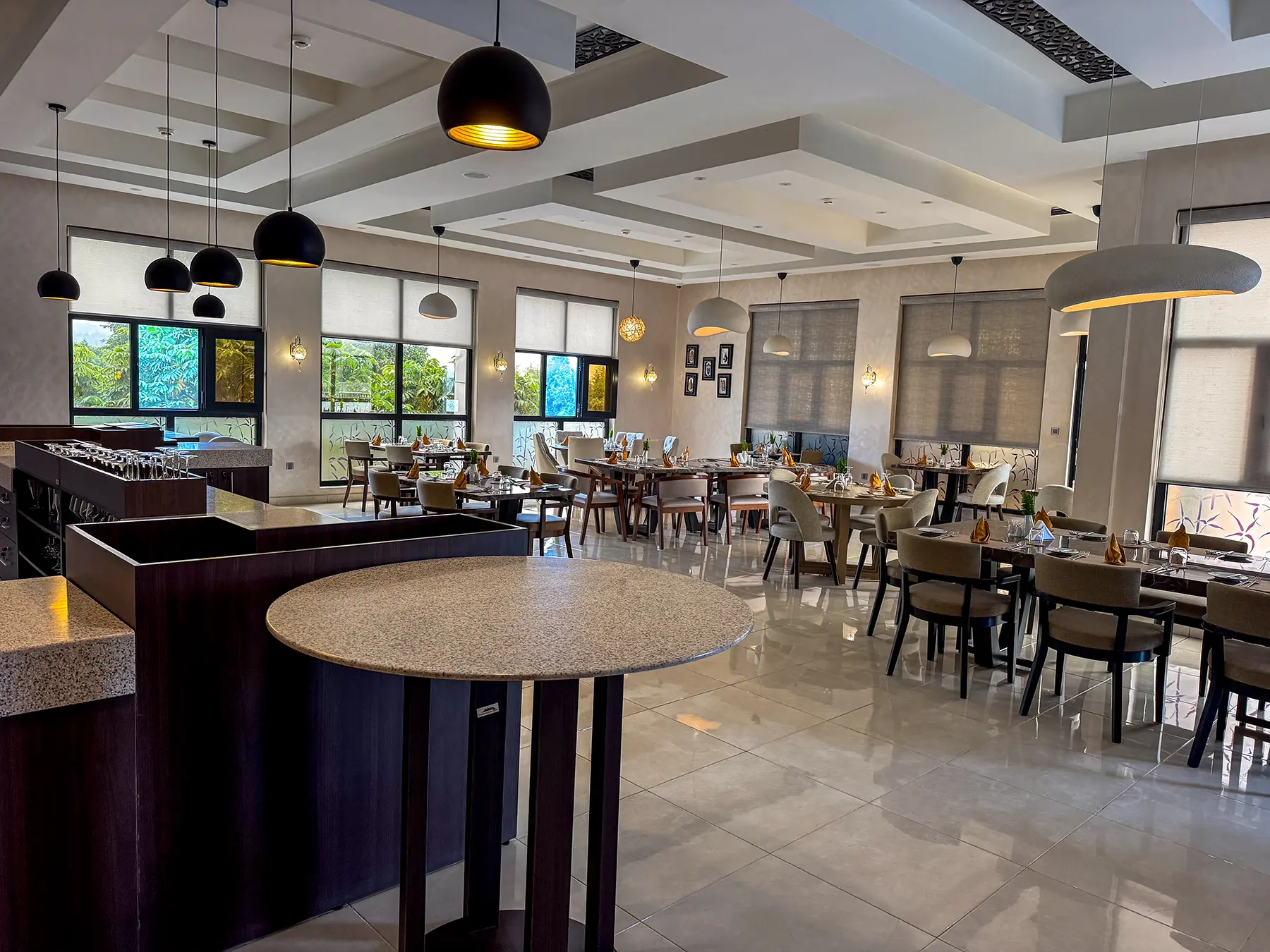 Modern restaurant with pendant lights and polished tiled floor at Virunga Inn in Volcanoes National Park, Rwanda
