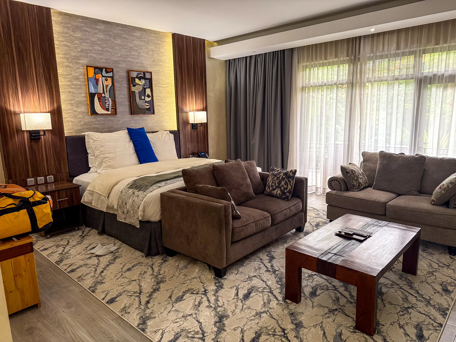 Spacious suite with king bed, sofas and patterned rug at Virunga Inn in Volcanoes National Park, Rwanda
