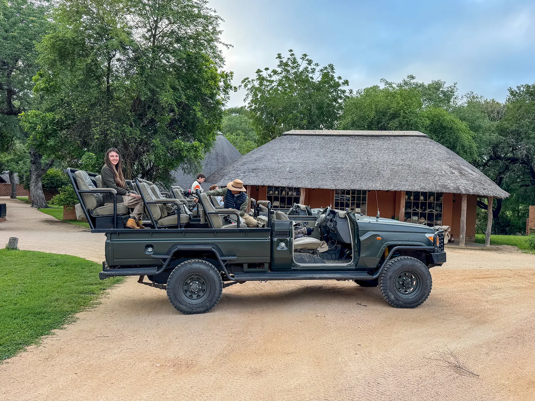 Ella McKendrick seated in a parked safari vehicle outside a thatched building on safari in MalaMala Game Reserve, South Africa