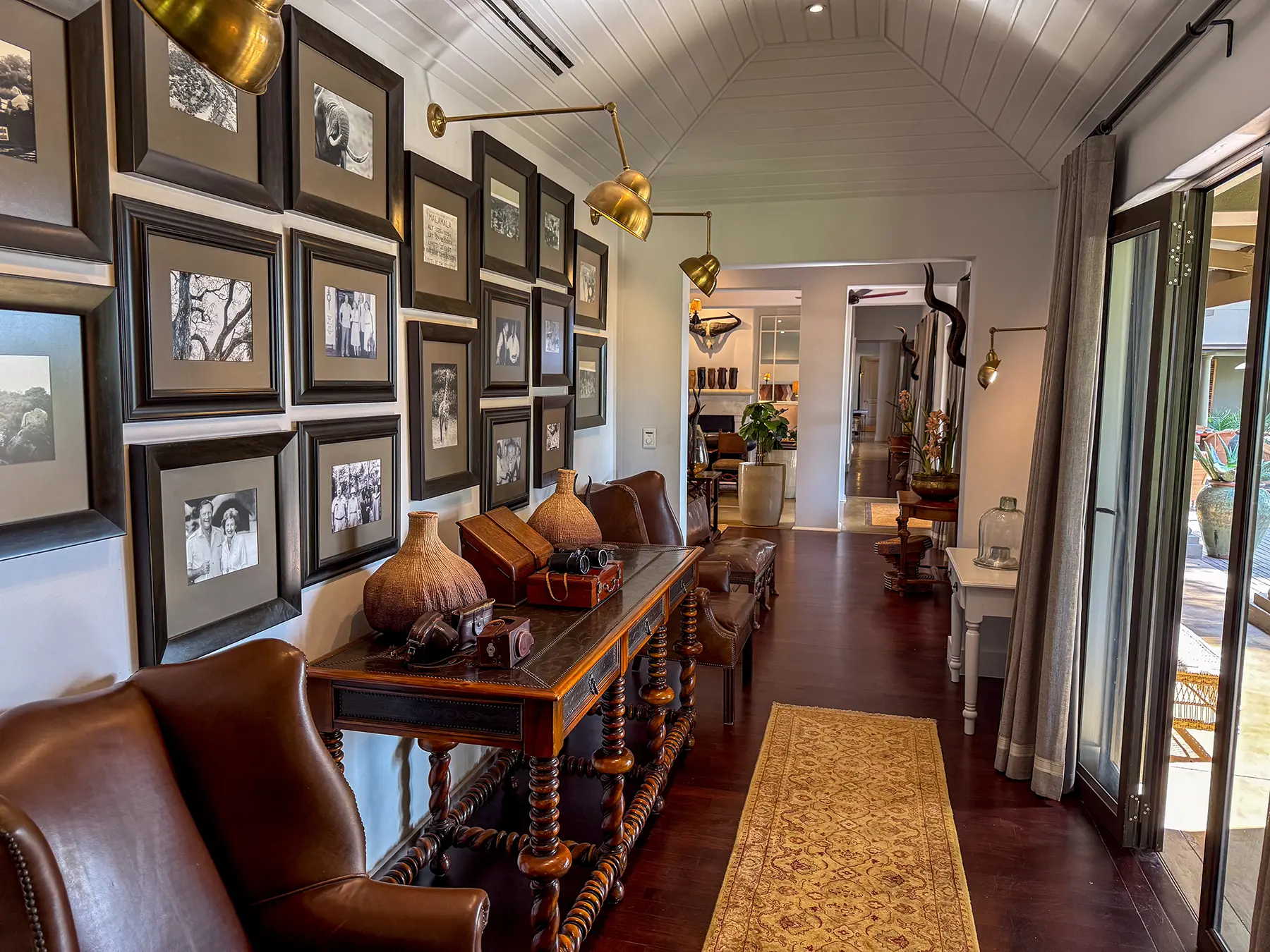 Hallway gallery with framed black and white photographs and antique cameras at Rattray's in MalaMala Game Reserve, South Africa